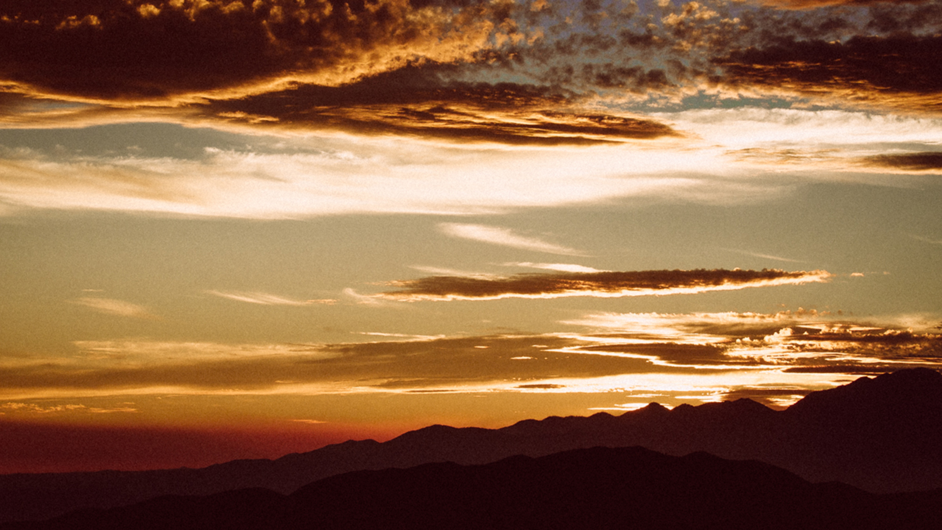 a desert landscape, griany, faded, setting sun and clouds