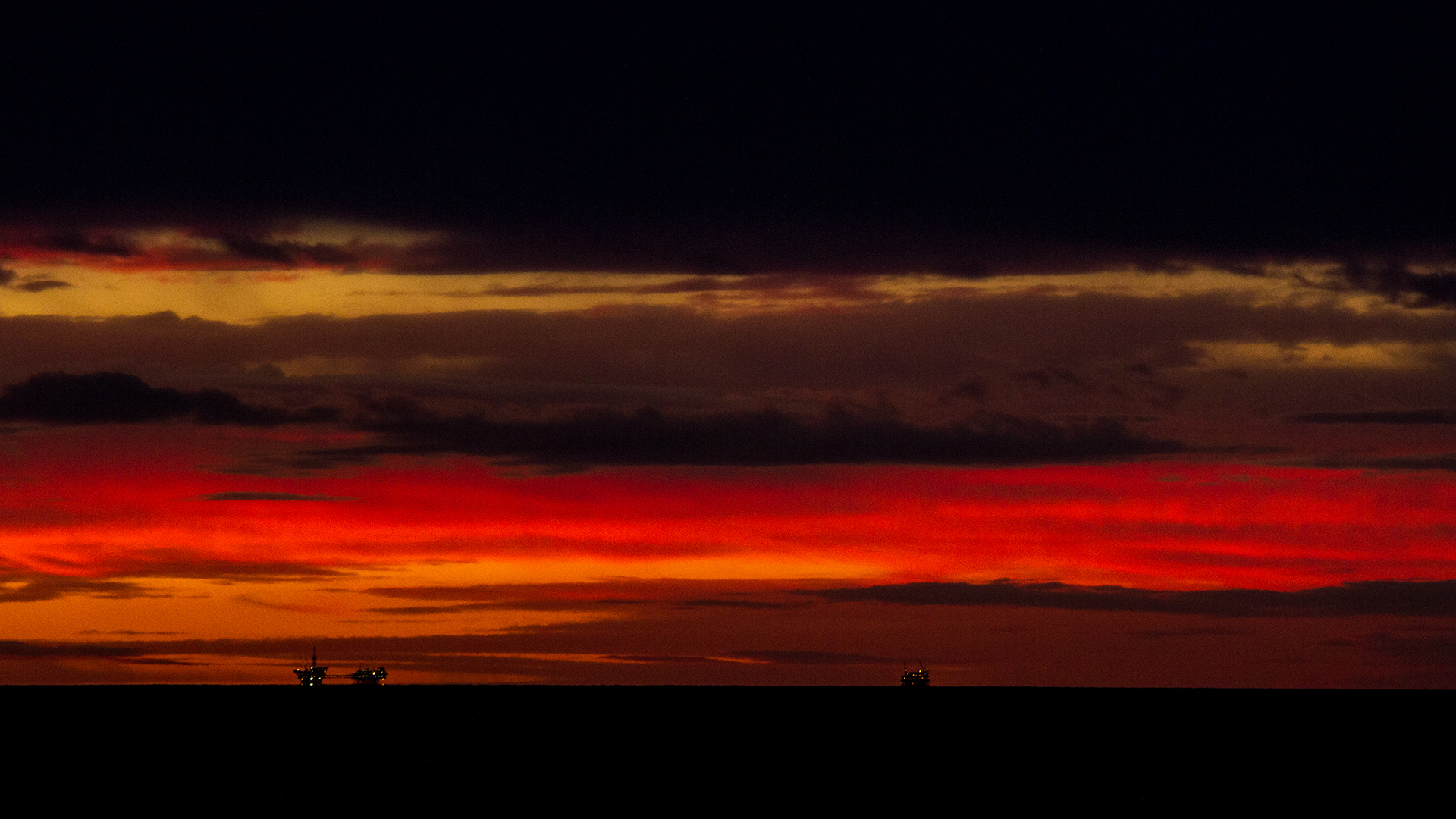 oil rigs and deep red sky